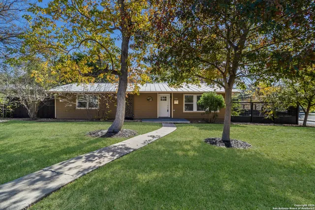 a tree in front of a white house