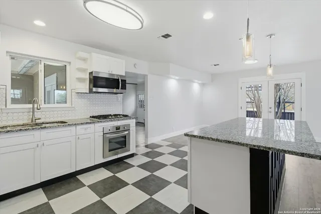 a kitchen with stainless steel appliances granite countertop a sink and a stove