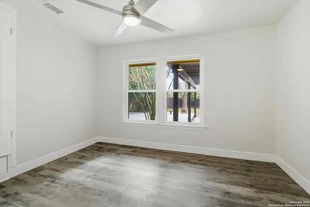 an empty room with a window and wooden floor
