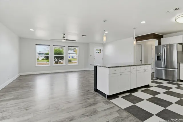 a kitchen with stainless steel appliances granite countertop a refrigerator and a stove top oven