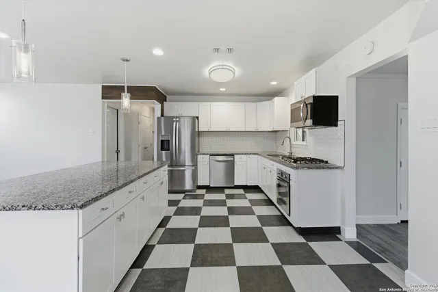 a kitchen with a checkered floor and white cabinets