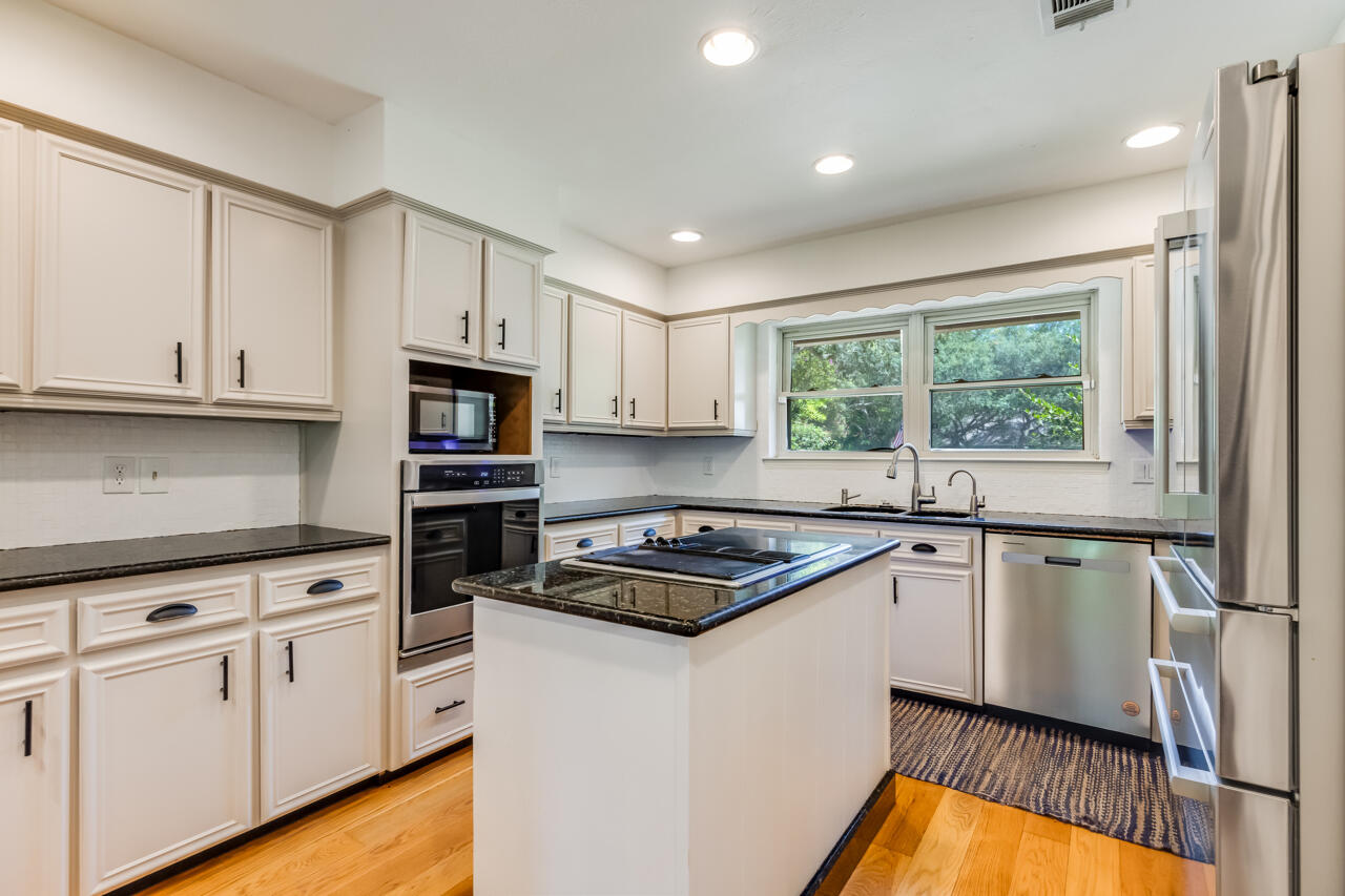 5 Cahaba Court Destin, FL 32541 - Photo 10 of 44 a kitchen with granite countertop white cabinets and white appliances