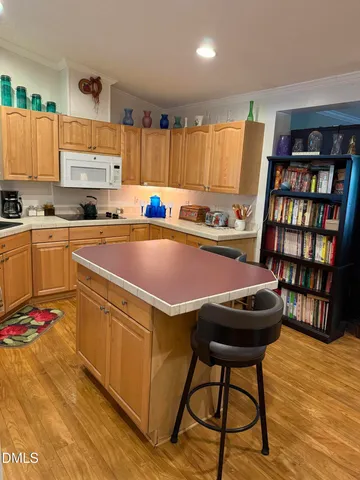 a kitchen with stainless steel appliances a stove a refrigerator white cabinets and a dining table