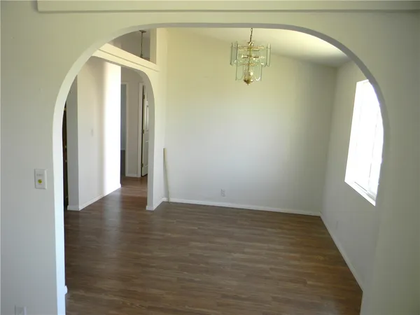 an empty room with wooden floor and mirror