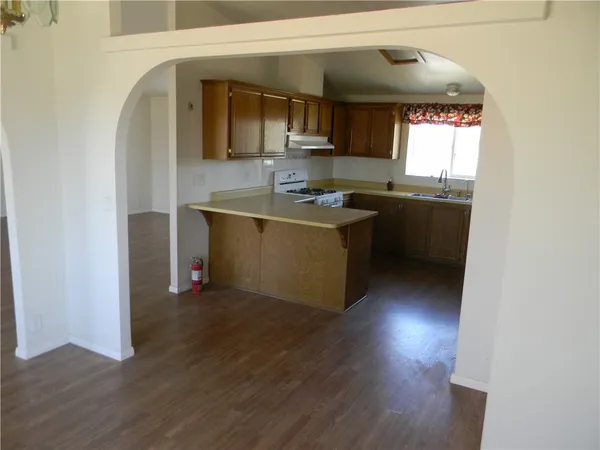 a kitchen with granite countertop a stove and a wooden floor