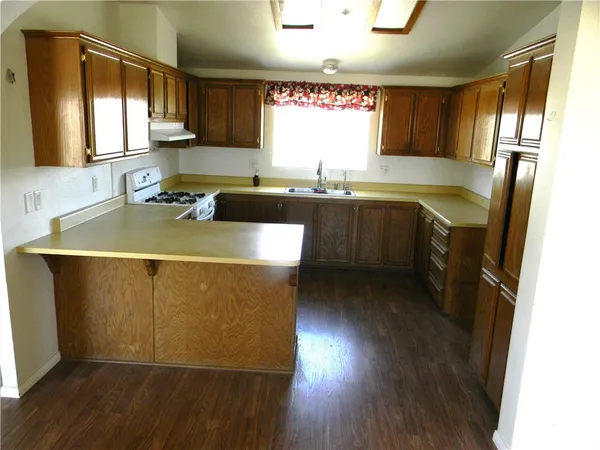 a kitchen with wooden floors sink and cabinets