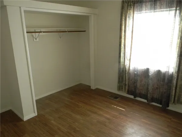 a view of a room with wooden floor and a window