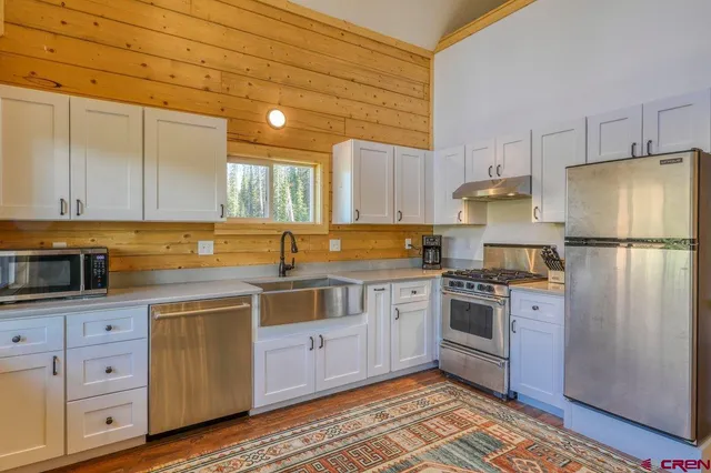 a kitchen with stainless steel appliances granite countertop a stove a sink and a refrigerator