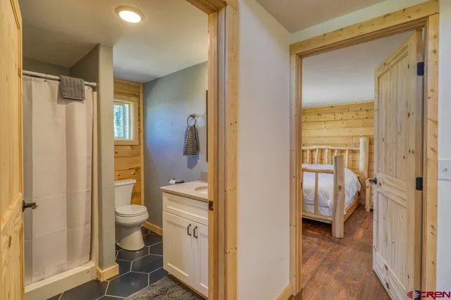 a bathroom with a granite countertop sink a toilet and shower