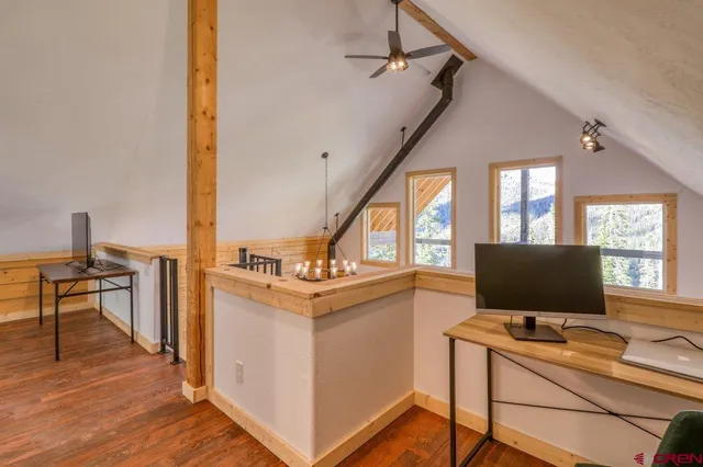 a view of a workspace with furniture and a window