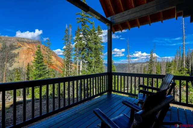 a view of a balcony with chairs and wooden floor