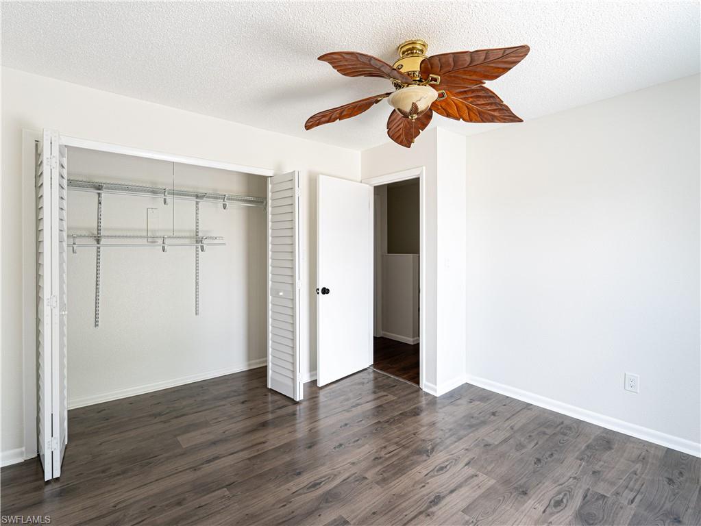 11001 Southeast Sunset Harbor Road, Unit 34 Summerfield, FL 34491 - Photo 19 of 31 Unfurnished bedroom featuring dark wood-type flooring, a closet, ceiling fan, and a textured ceiling