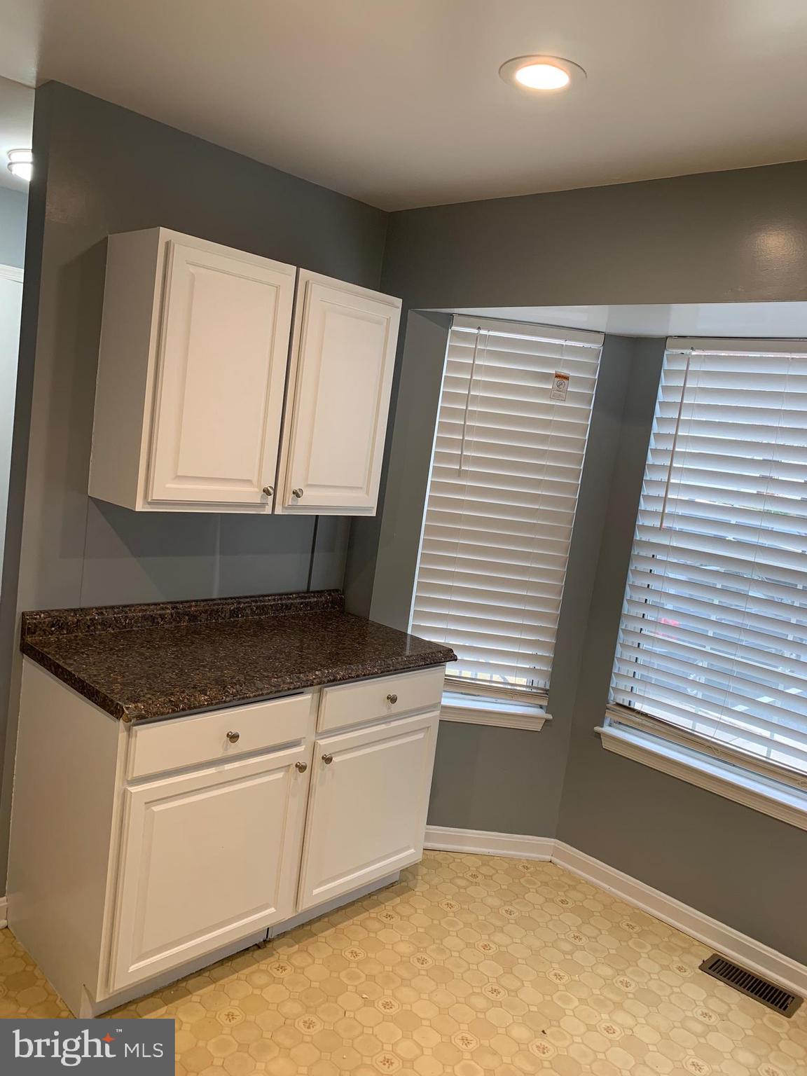 8555 Ritchboro Road District Heights, MD 20747 - Photo 27 of 30 a kitchen with granite countertop white cabinets and white appliances