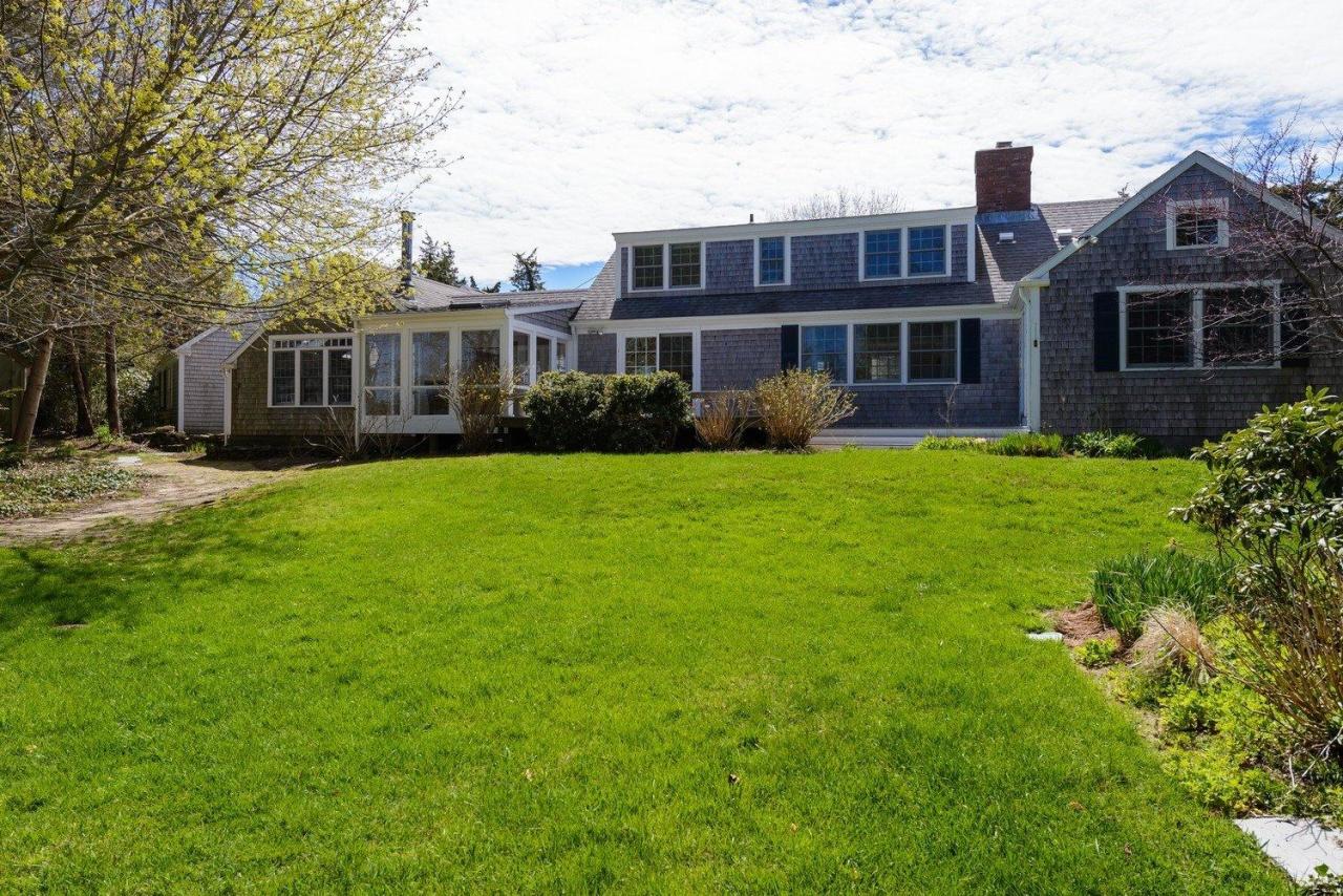52 Salten Point Road Barnstable, MA 02630 - Photo 2 of 24 a view of a yard in front of a brick house with many windows