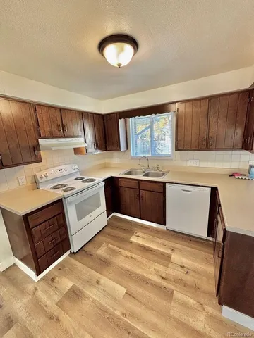 a view of a hallway with wooden floor and entryway