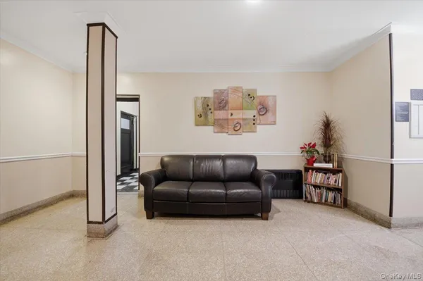 a living room with furniture and a refrigerator