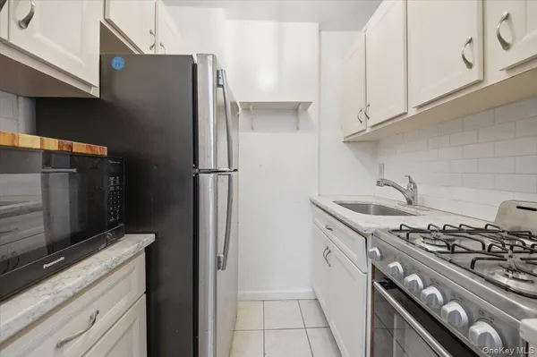 a kitchen with stainless steel appliances granite countertop a refrigerator and a stove