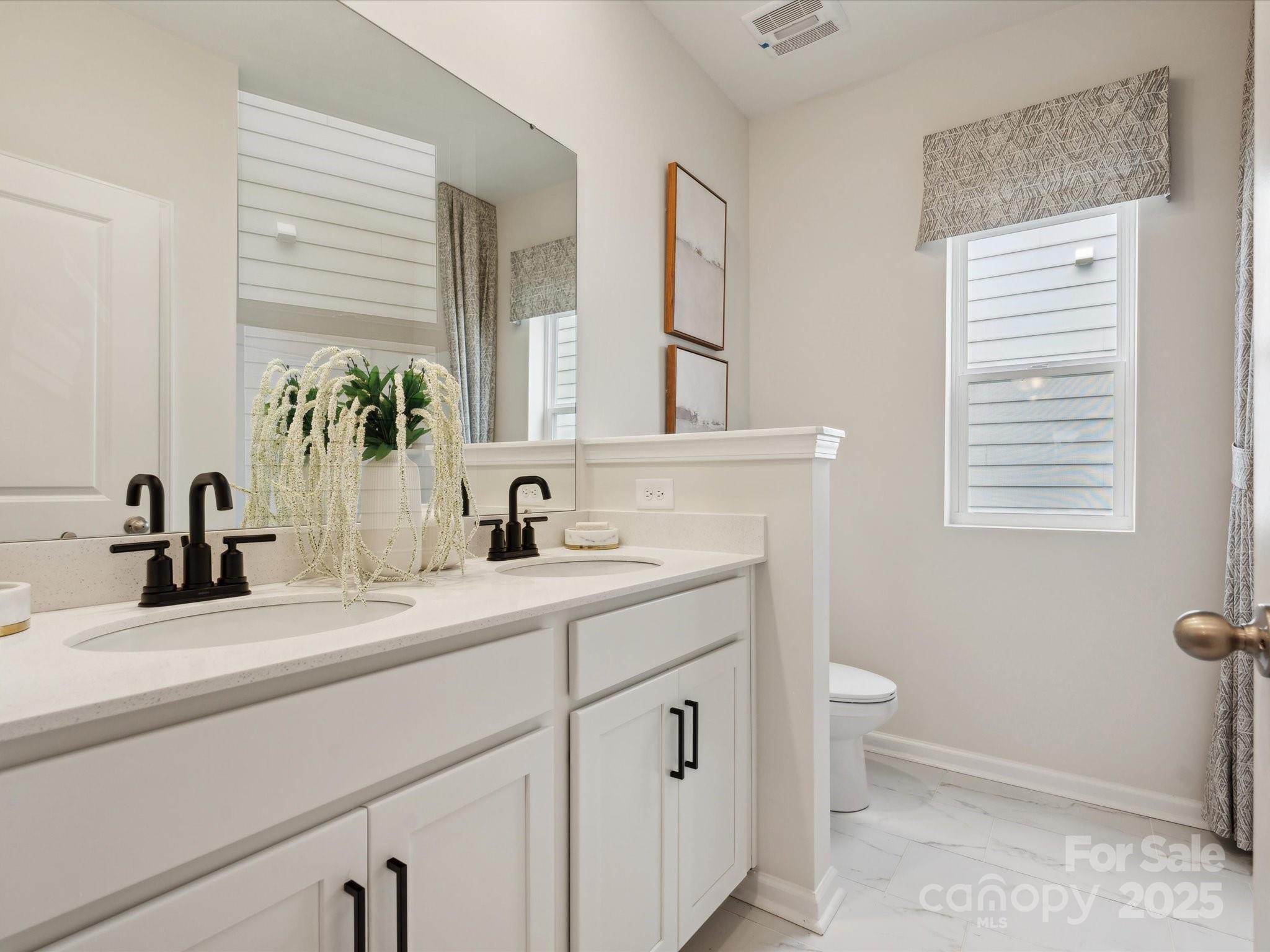 2012 Rosefield Court Matthews, NC 28104 - Photo 12 of 14 a bathroom with a double vanity sink a mirror and a toilet
