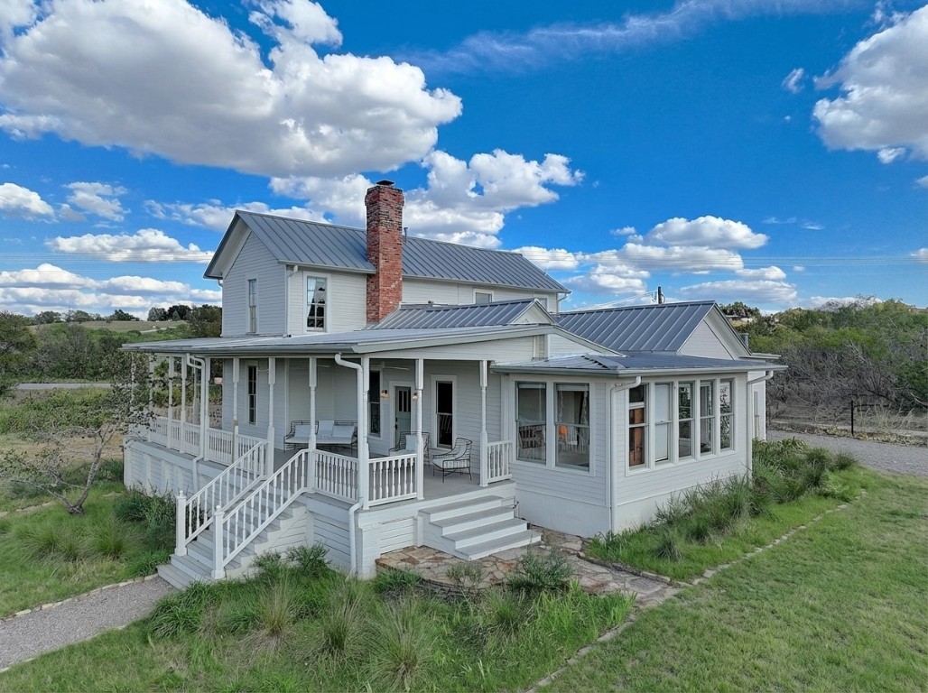 11228 Parsons Road Manor, TX 78653 - Photo 1 of 40 Back of property featuring a porch, a chimney, a metal roof, and a yard