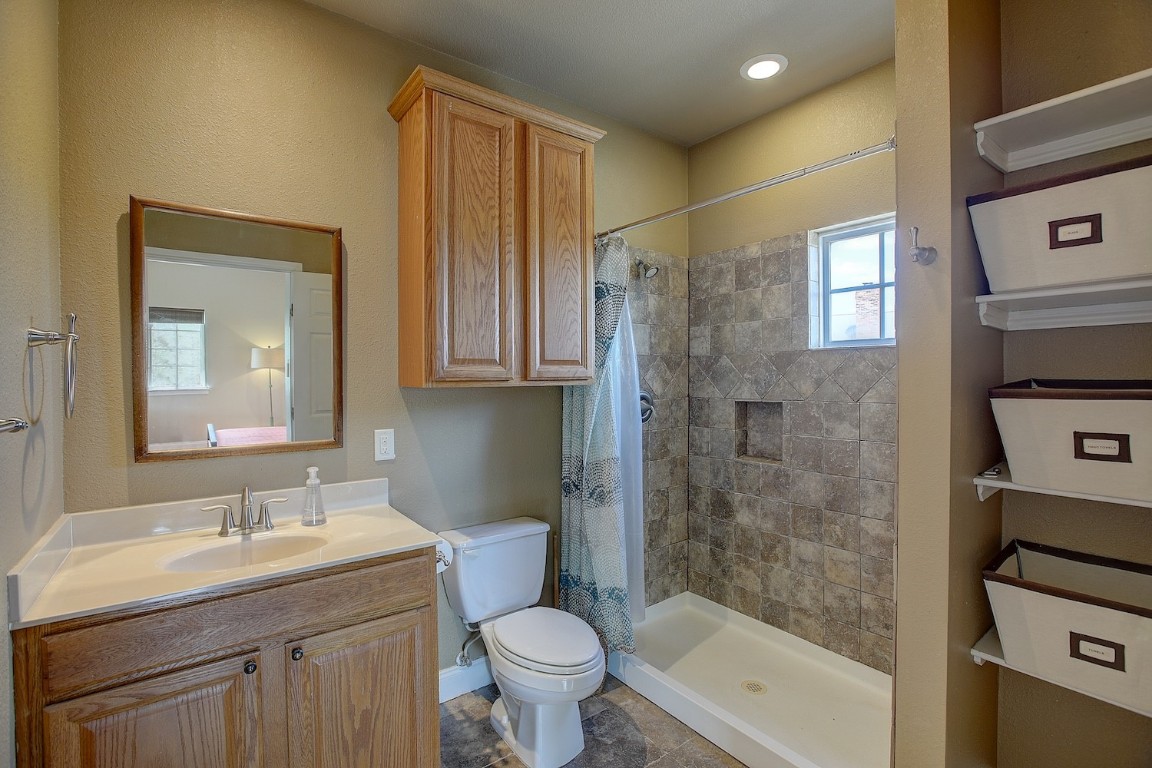 11228 Parsons Road Manor, TX 78653 - Photo 36 of 40 a bathroom with a granite countertop sink toilet and shower