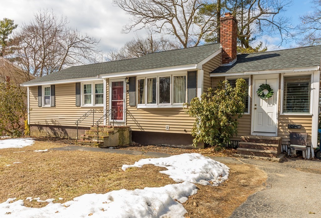 a front view of a house with a yard covered in snow