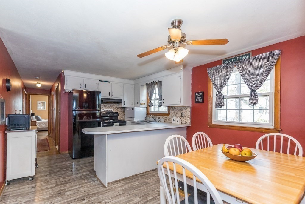 5 Harnden Road Billerica, MA 01821 - Photo 7 of 17 a kitchen with stainless steel appliances granite countertop a sink a stove top oven a dining table and chairs with wooden floor