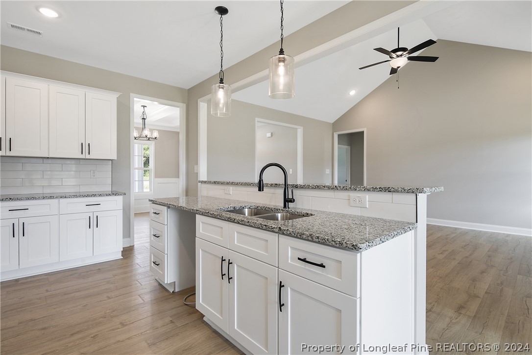 175 Spring Branch Road Tar Heel, NC 28392 - Photo 23 of 50 a kitchen with sink cabinets and wooden floor