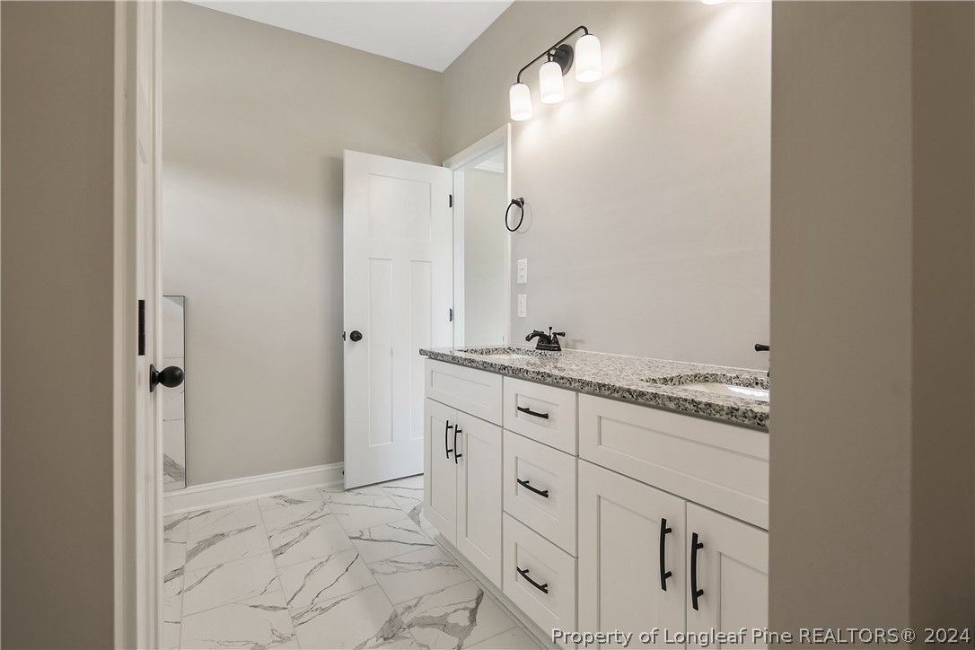 175 Spring Branch Road Tar Heel, NC 28392 - Photo 32 of 50 a bathroom with a granite countertop sink and a mirror