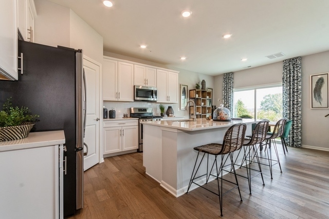 1327 Draper Road McHenry, IL 60050 - Photo 4 of 10 a kitchen with kitchen island granite countertop wooden floors and stainless steel appliances