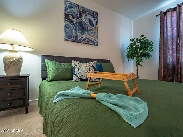 a bedroom with a bed and a potted plant