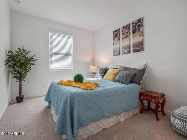 a bedroom with bed and a potted plant