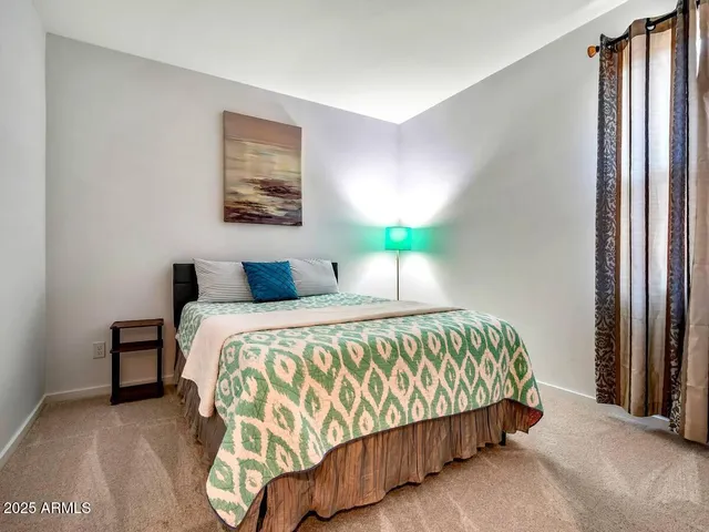 a bedroom with a bed and painting on the wall