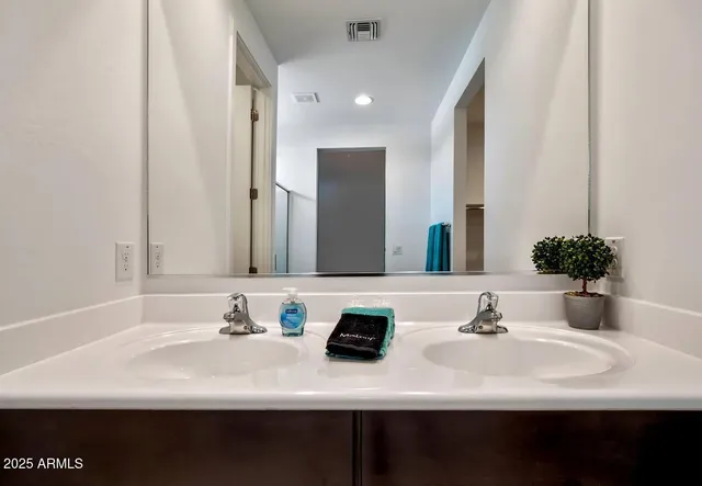 a bathroom with double sink and a mirror