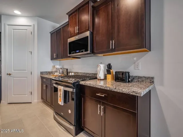 a kitchen with stainless steel appliances granite countertop a sink stove and microwave