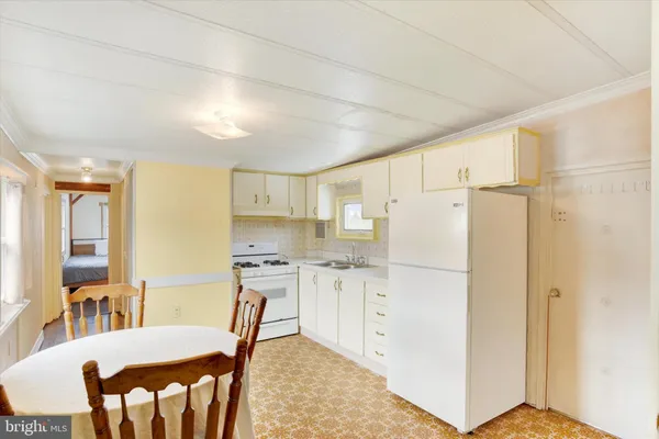 a kitchen with stainless steel appliances granite countertop a refrigerator a stove a sink dishwasher and a dining table with wooden floor