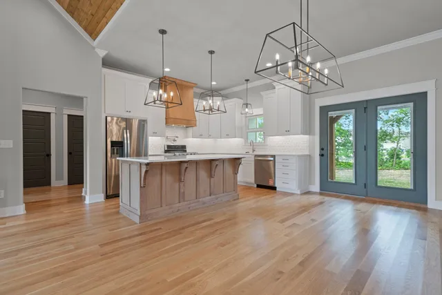 a view of a kitchen with a chandelier wooden floor and a chandelier