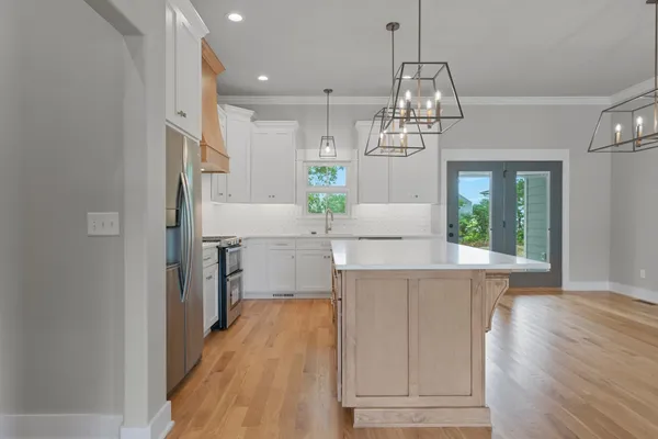 a kitchen with kitchen island a counter top space appliances and cabinets