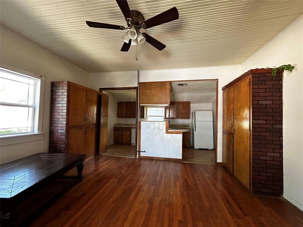 910 West Long, Unit A Stephenville, TX 76401 - Photo 22 of 39 a kitchen with stainless steel appliances wooden floor large window and wooden floors
