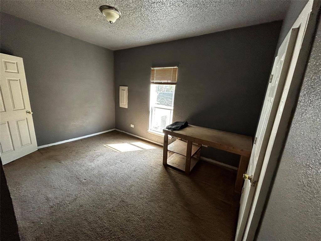 910 West Long, Unit A Stephenville, TX 76401 - Photo 33 of 39 a view of an empty room with wooden floor and a window