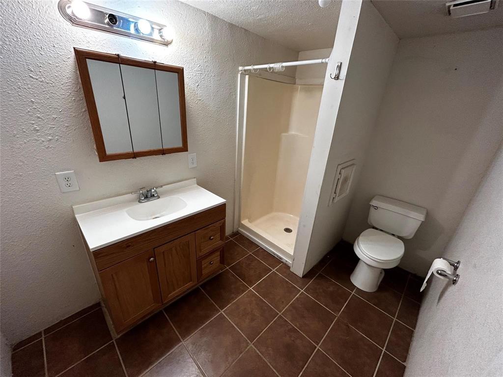 910 West Long, Unit A Stephenville, TX 76401 - Photo 35 of 39 a bathroom with a toilet sink and mirror