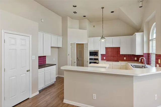 a kitchen with stainless steel appliances a refrigerator and a stove top oven