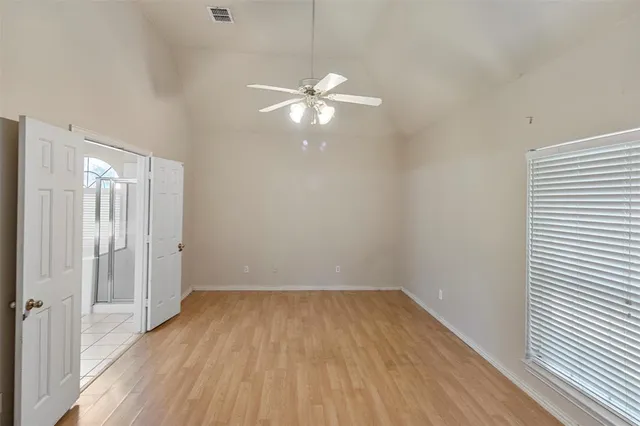 a view of a room with wooden floor and a ceiling fan