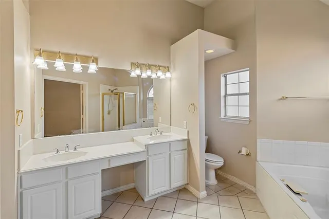 a bathroom with a double vanity sink mirror and toilet