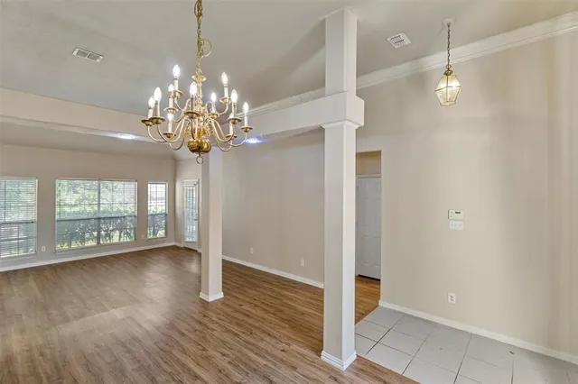 a view of a livingroom with wooden floor and a chandelier
