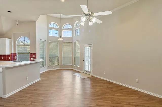 a view of a hallway with wooden floor and a chandelier