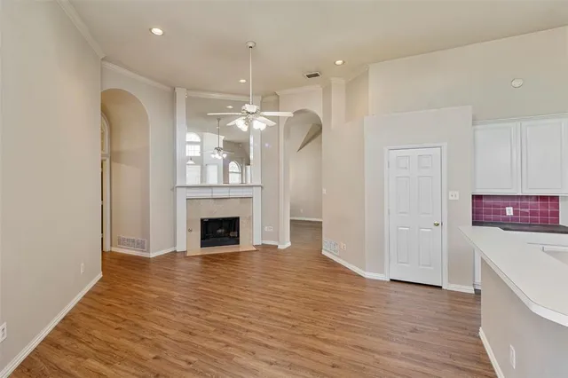 a view of a livingroom with a fireplace a chandelier and wooden floor