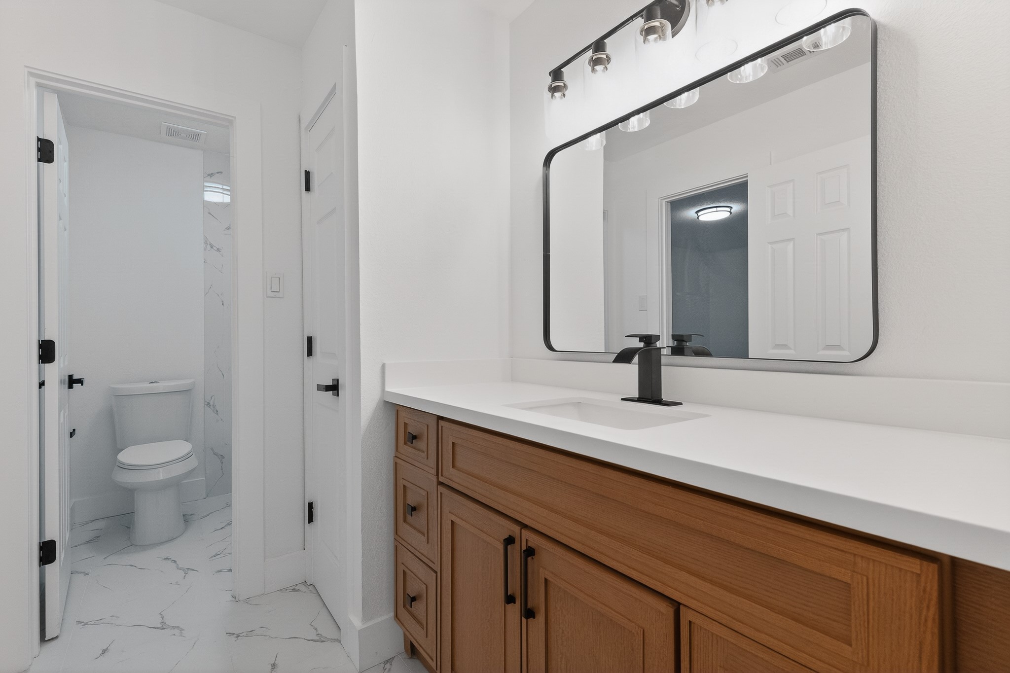 523 Rampart Lane Conroe, TX 77302 - Photo 26 of 41 Updated secondary bath with quartz countertops, custom cabinetry, designer fixtures, and modern finishes throughout.