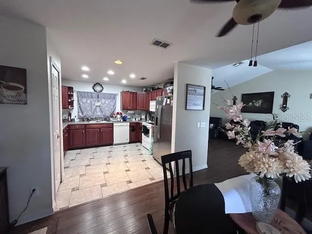 a view of a dining room and livingroom with furniture wooden floor a chandelier