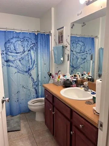 a bathroom with a granite countertop sink mirror vanity and toilet