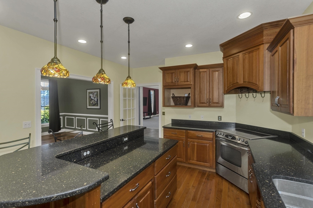 333 Stebbins Street Belchertown, MA 01007 - Photo 6 of 42 a kitchen with stainless steel appliances granite countertop a sink a stove and a wooden cabinets